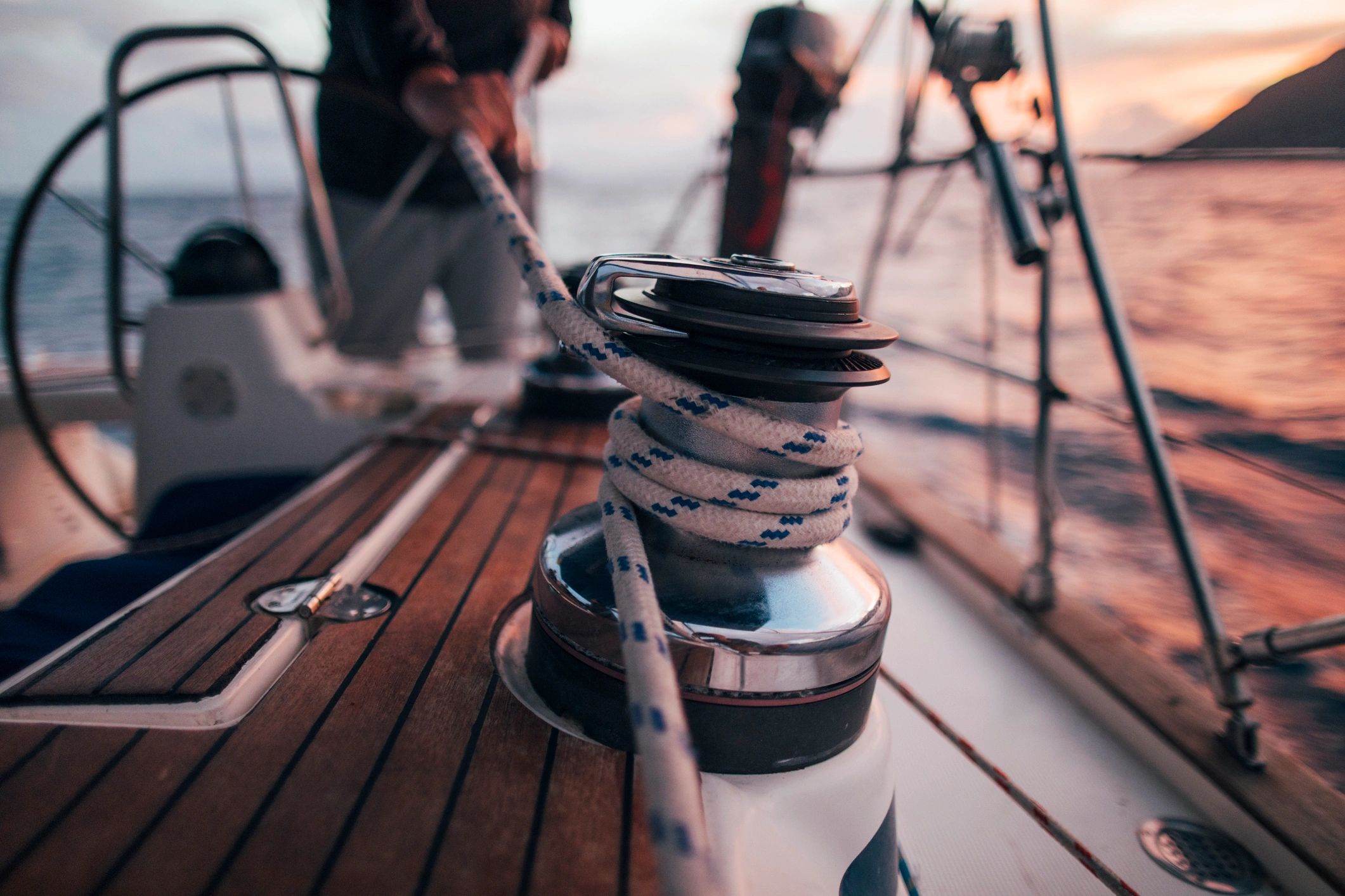 Rope being handled on a sailboat winch, representing hands-on maintenance