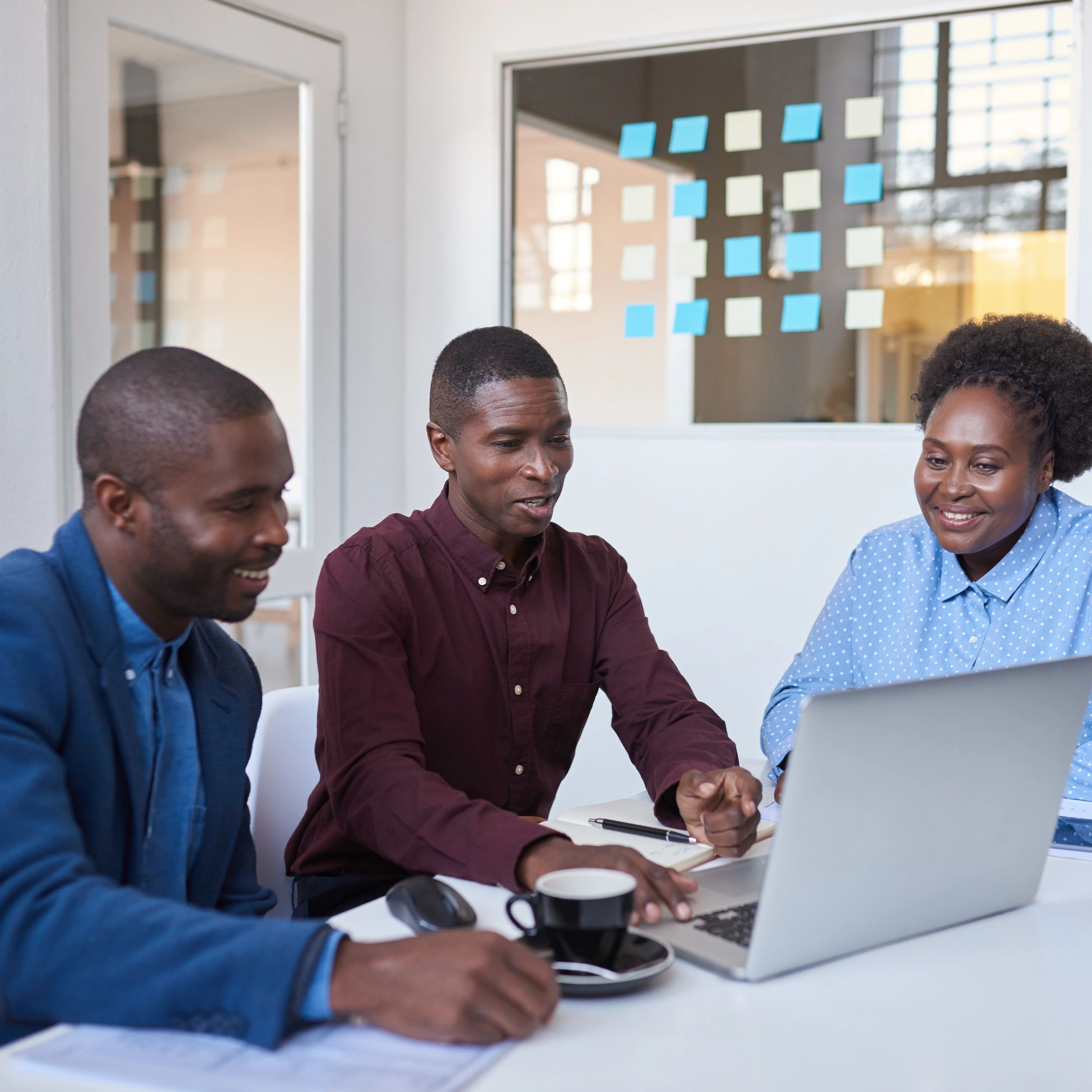 Coworkers smiling while working on a laptop