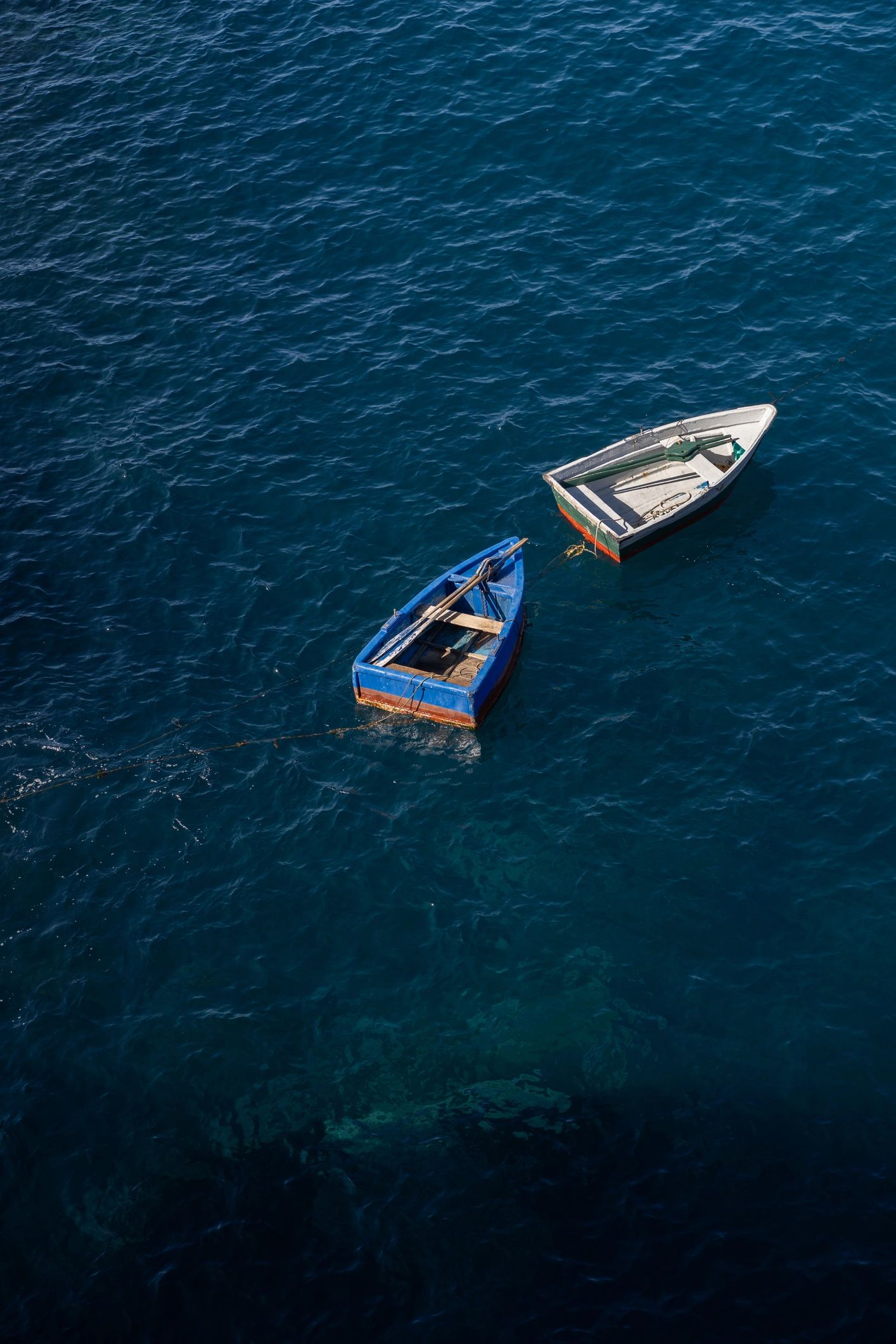 Boats on calm water near a coastal hillside