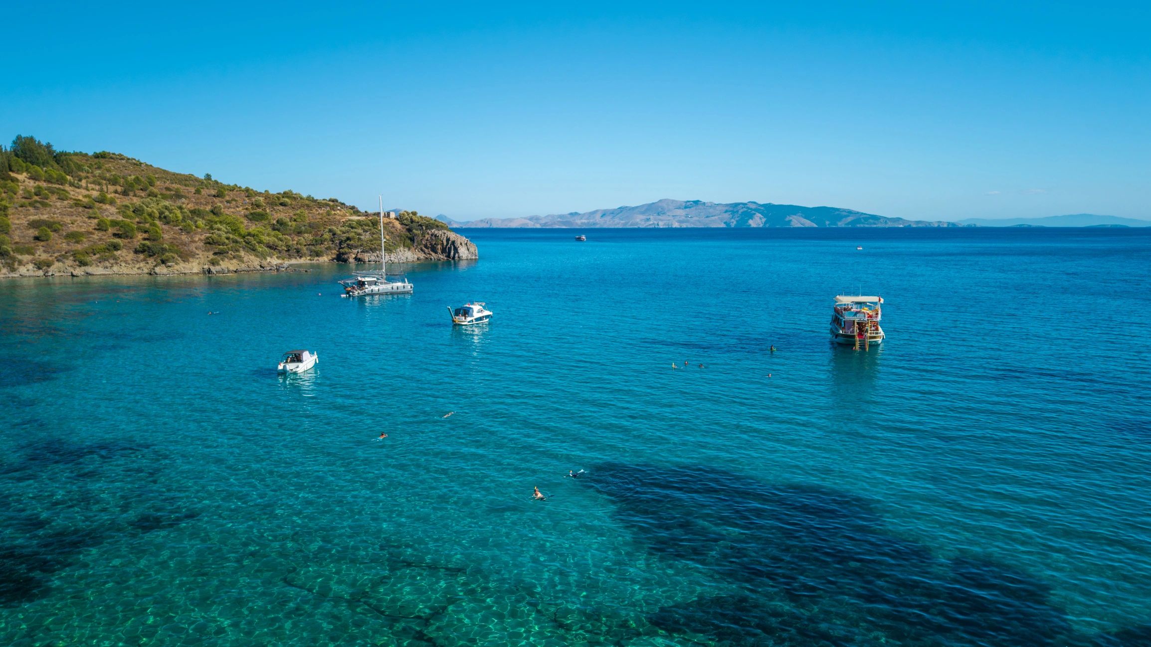 Aerial view of sailboats and yachts in a blue coastal bay