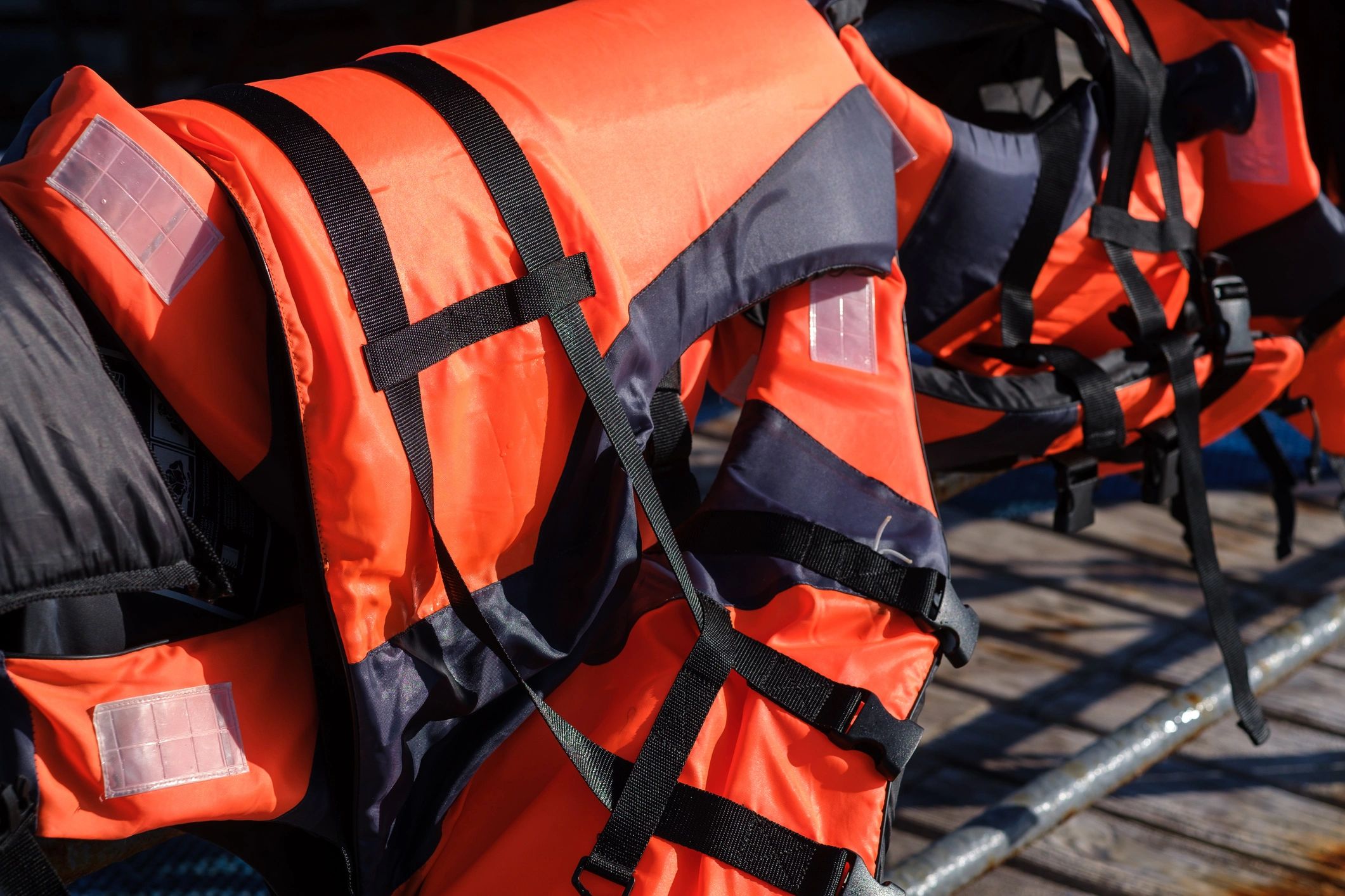 Bright orange life jackets hanging on a rack