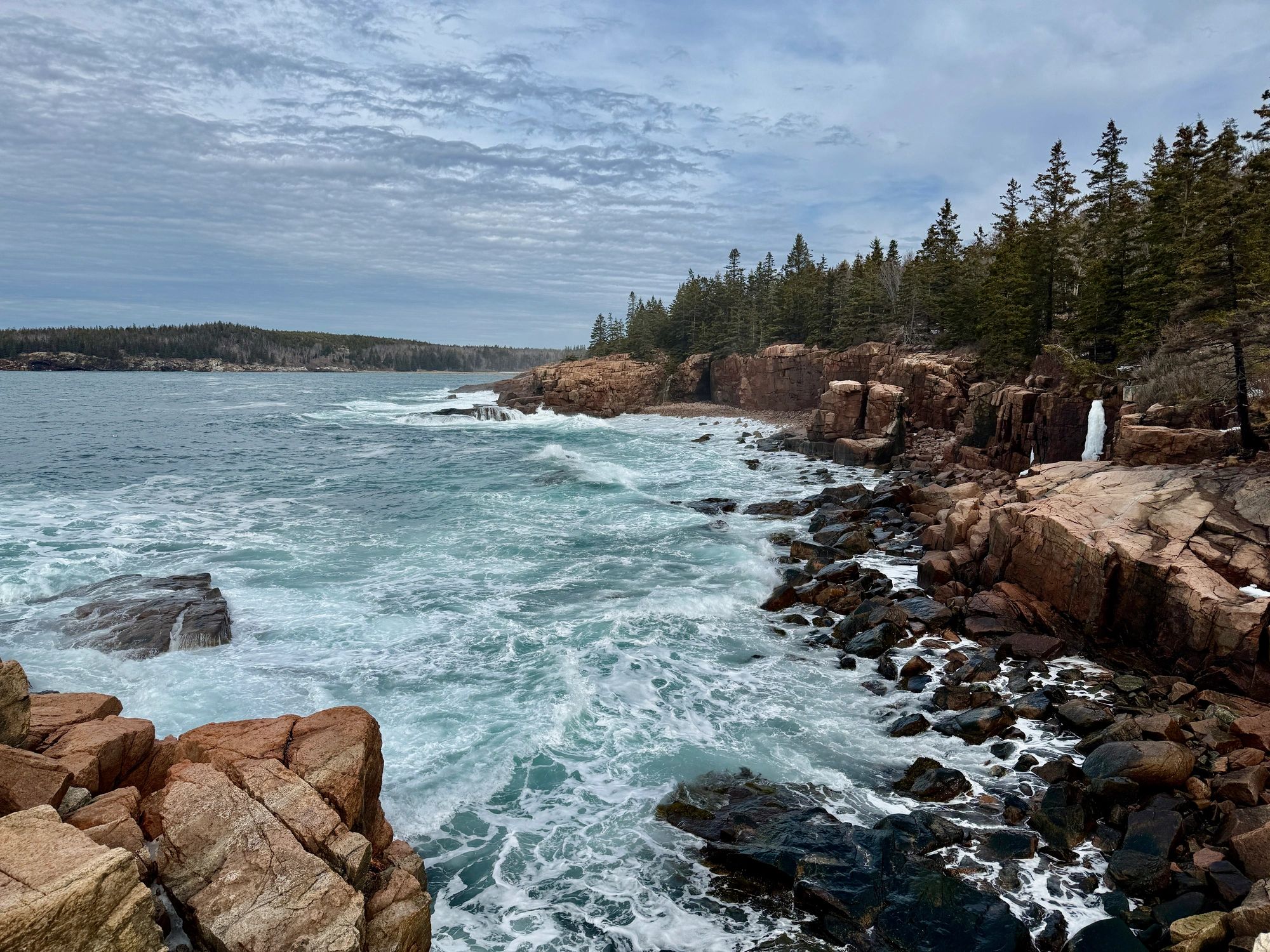 Rocky New England coastline near a lighthouse