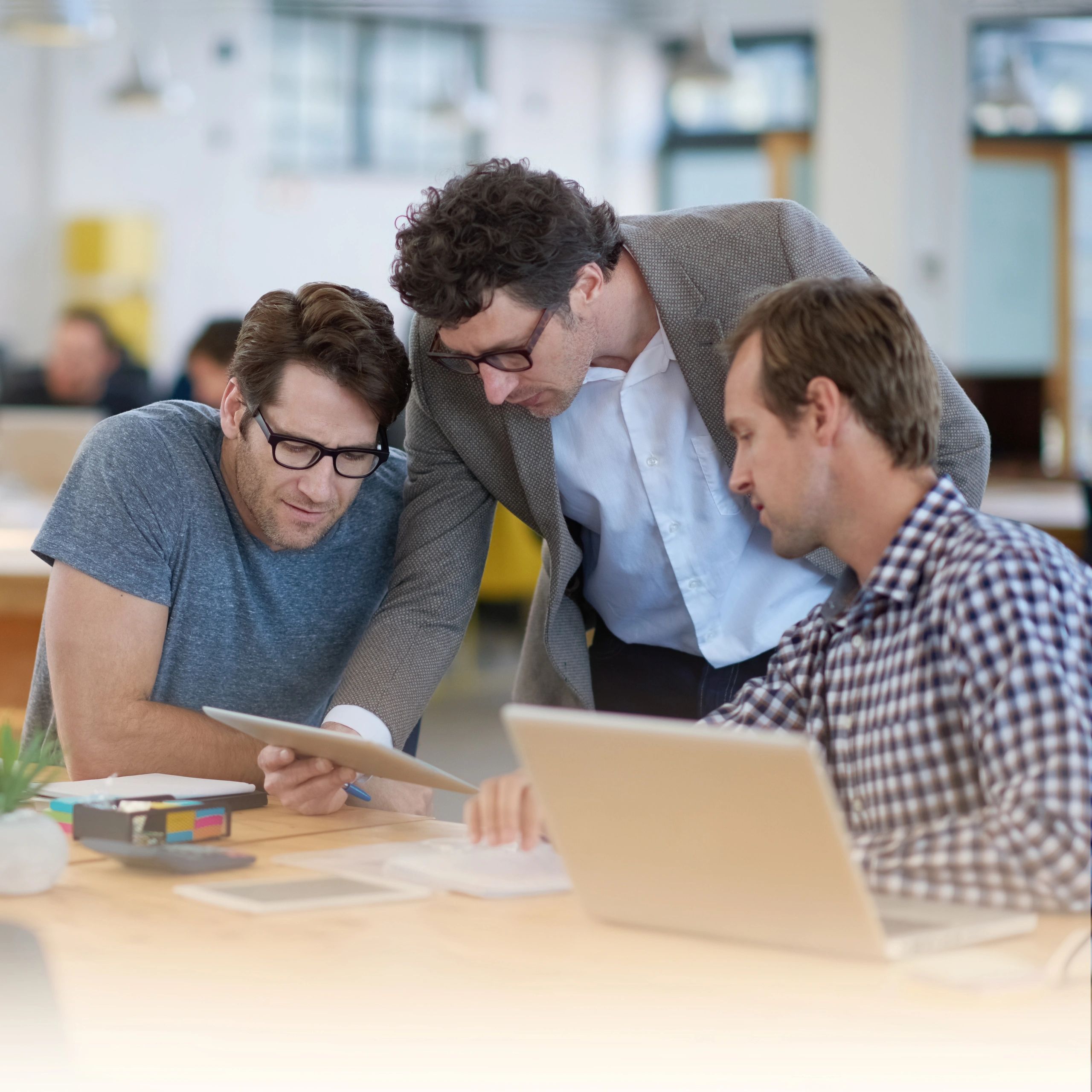 Colleagues discussing work on a tablet